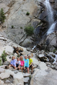 kids on log at waterfall