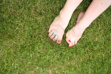 14185453-womans-bare-feet-on-the-fresh-green-grass